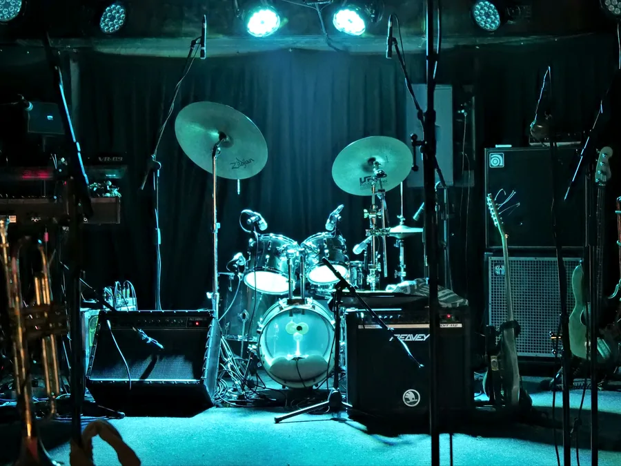 Set drum, ampli, dan gitar siap dimainkan di atas panggung