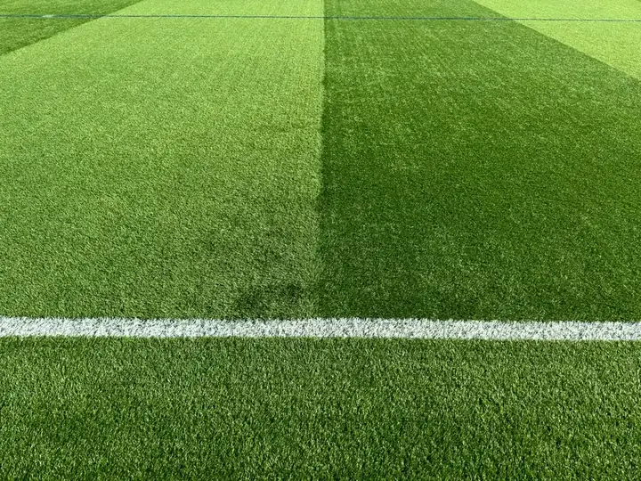 Hamparan rumput sintetis hijau bergaris putih