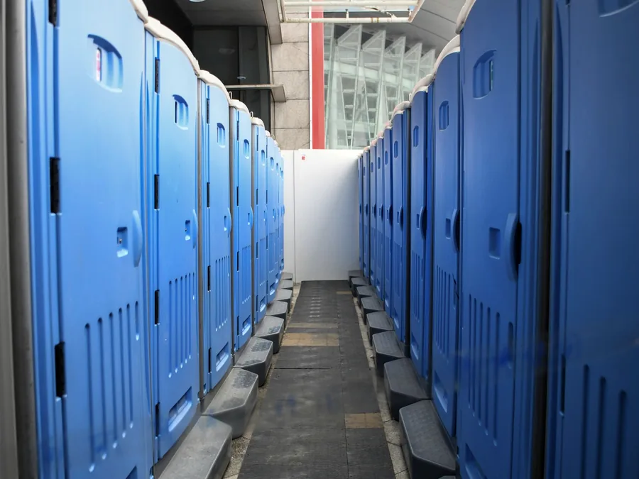 Deretan toilet portable biru berjajar rapat di lokasi acara
