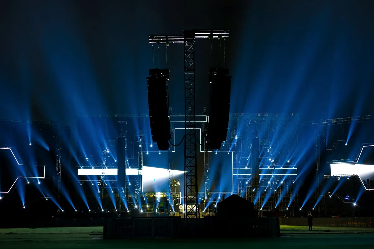 Panggung konser dengan tumpukan speaker dan sinar lampu, kategori audio besar