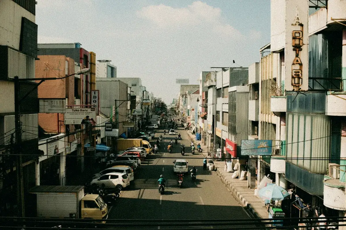Jalan kota padat dengan deretan ruko dan kendaraan, area layanan Bekasi